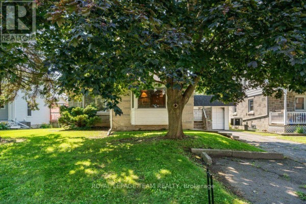 View of the bungalow's front entrance with a large tree partially obscuring the view. - 485 Fred Street, North Dundas