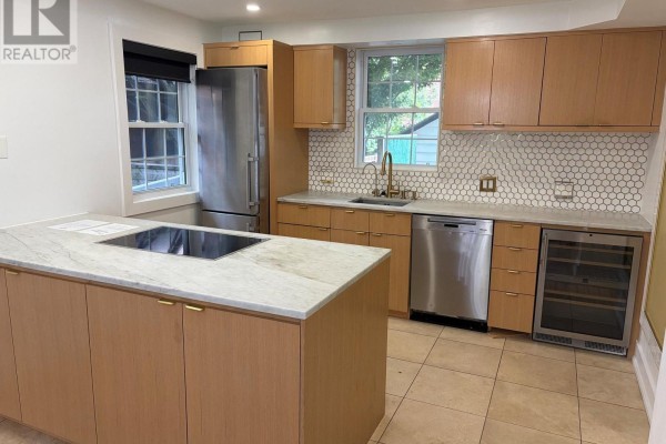 Kitchen with light wood cabinets, stainless steel appliances, granite island, and tile floor. - 485 Regent Street, London East