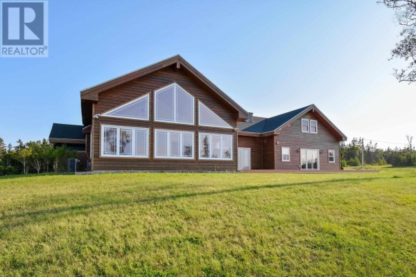 Open concept kitchen and dining area with wooden cabinets and light wood floors. - 485&489 Maple Drive, Cape George