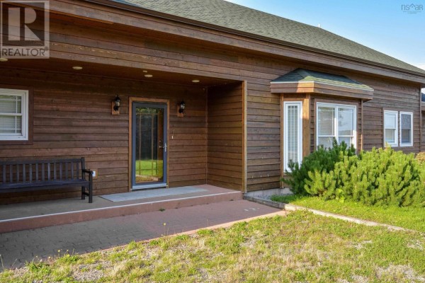Exterior view of a two-car garage with wood siding and grass surroundings. - 485&489 Maple Drive, Cape George