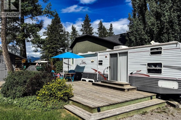 Deck and trailer with trees and mountains in the background. - 4868 Riverview Drive Unit# Lot 116, Edgewater