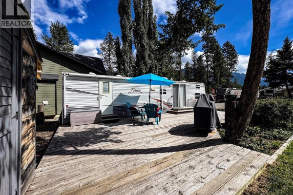 Wooden deck with chairs, table, grill, and tree. - 4868 Riverview Drive Unit# Lot 116, Edgewater