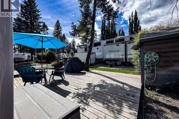 Deck with patio furniture, grill, and RVs in the distance. - 4868 Riverview Drive Unit# Lot 116, Edgewater