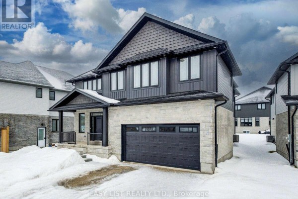 Side view of the house showing a porch and double garage in winter setting. - 487 Black Street, Centre Wellington