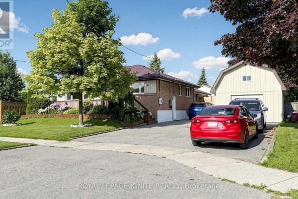 Driveway with a red car and silver SUV parked in front of a detached garage and bungalow. - 487 Wilson Road S, Oshawa