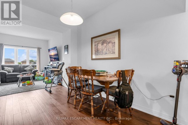 Dining area with wooden table and chairs next to a living room. - 4879 Connor Drive, Lincoln