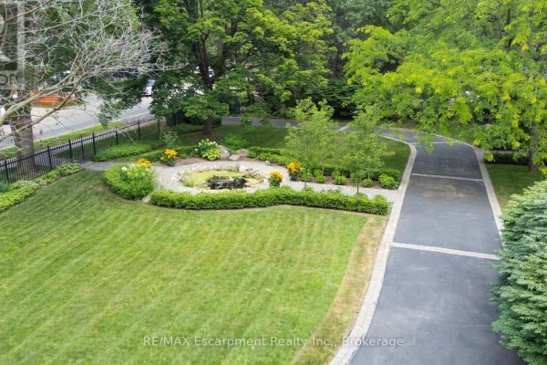 Rear exterior of the house with a large sunroom and multiple balconies overlooking the backyard. - 488 Macdonald Road, Oakville