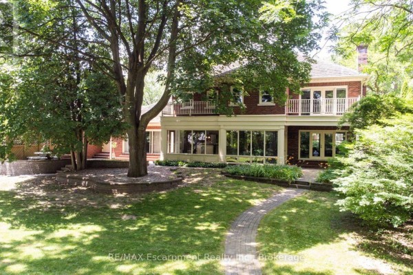 Aerial view showing the house's roof, circular driveway, and surrounding mature trees. - 488 Macdonald Road, Oakville