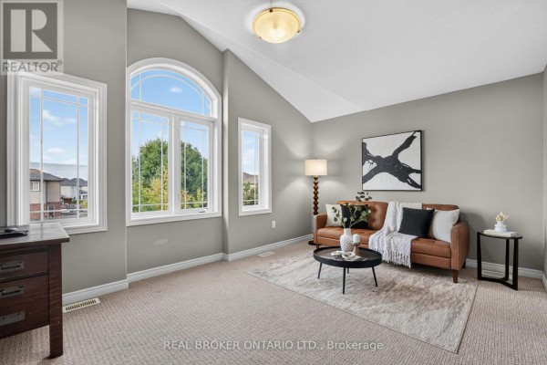 Living room with vaulted ceiling, large arched window, brown leather sofa, and a black and white abstract painting. - 4890 Allan Court, Lincoln