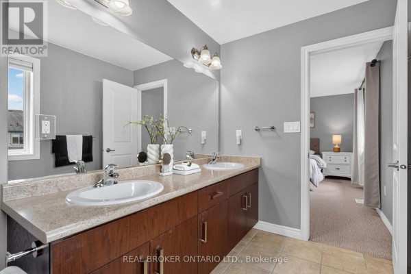 Double vanity bathroom with a granite countertop, dark wood cabinets, and a mirror reflecting the bedroom. - 4890 Allan Court, Lincoln