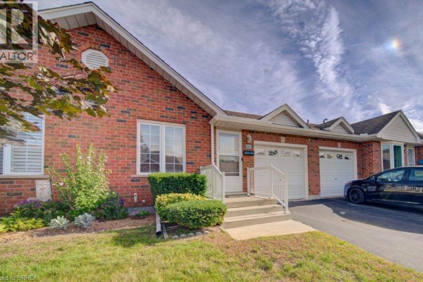 Front exterior view of a brick townhouse with a white door, garage, and lawn. - 48c Harris Avenue, Brantford