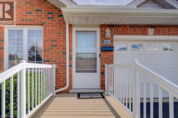 Close-up of the townhouse front door with a screen door, mailbox, and garage. - 48c Harris Avenue, Brantford