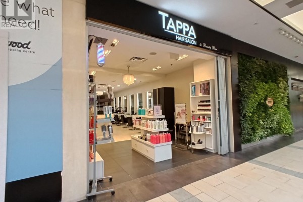 Front view of Tappa Hair Salon showing product shelves, reception desk, and salon chairs visible through the open entrance. - 49 - 2121 Carling Avenue, Ottawa