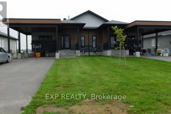 Front exterior of attached townhomes with carports and asphalt driveways. - 49 - 55 Adam Street, The Nation