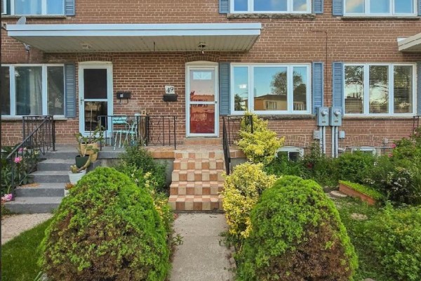 A view of the townhouse exterior showing the entrance and windows. - 49 - 740 Kennedy Road, Toronto