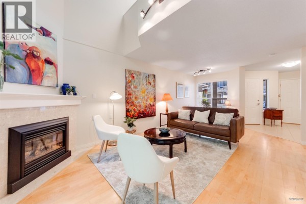 Living room with light wood floors, cream walls, and a gas fireplace. - 49 650 Roche Point Drive, North Vancouver