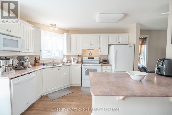 Kitchen with white cabinets, appliances, and island - 49 Barnhart Drive South Stormont