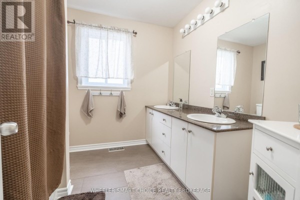 Dual-sink bathroom with granite countertops and large mirror - 49 Barnhart Drive South Stormont