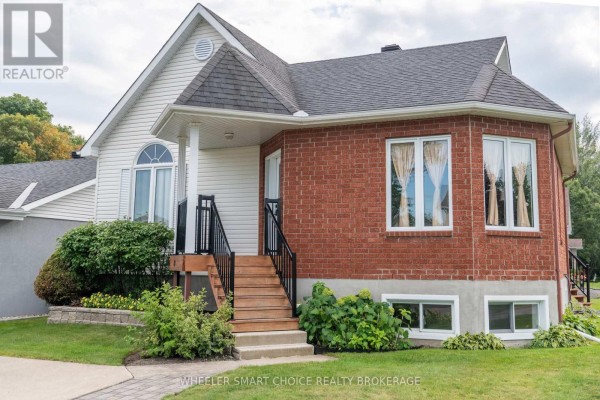 House exterior with red brick and vinyl siding, wooden steps, and landscaping - 49 Barnhart Drive South Stormont