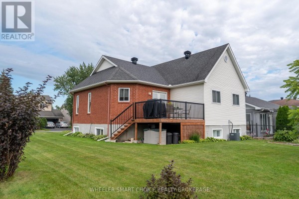 Brick and vinyl siding home with deck and lawn - 49 Barnhart Drive South Stormont