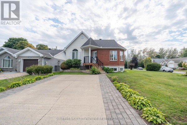 Concrete driveway with interlocking brick walkway leading to a brick and white sided house. - 49 Barnhart Drive, South Stormont