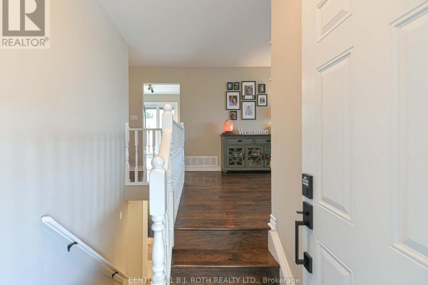 View from the front door looking into a hallway with wood floors and stairs. - 49 Bond Street, Orillia