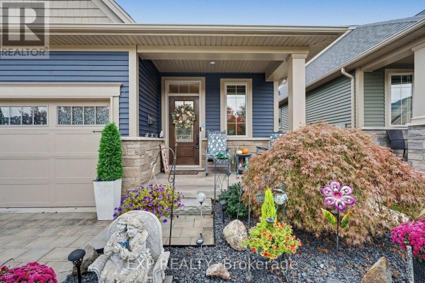 Entrance porch of a townhouse with a glass-paneled front door, window, and decorative porch seating. - 49 Campbell Street, Thorold