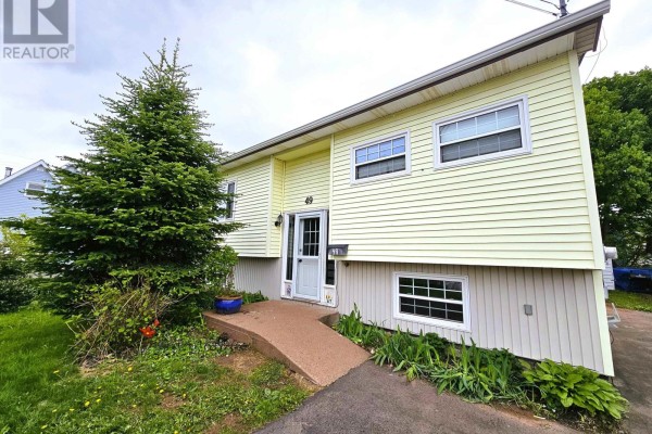 Corner view of a room with gray and cream paneled walls, wood-look flooring, and a window. - 49 Hill Street, Amherst