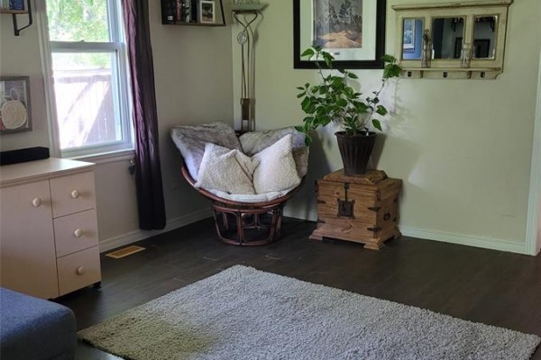 Backyard with a fire pit, wooden seats, and a wooden fence surrounding the lawn. - 49 Kennedy, Brantford