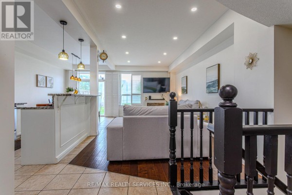 Interior entryway with a white door, tiled floor, console table, mirror, and decorative items. - 49 Marina Point Crescent N, Hamilton