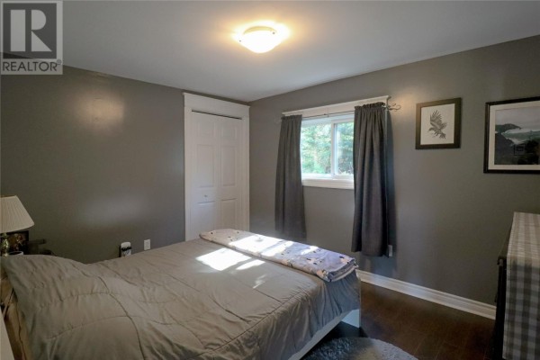 Bedroom with dark grey walls, a queen-size bed, and a double-door closet. - 49 Maxwell Place, St  John S