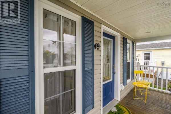 Close-up view of the front door, windows, and porch of a beige mobile home. - 49 Merriweather Crescent, Garlands Crossing