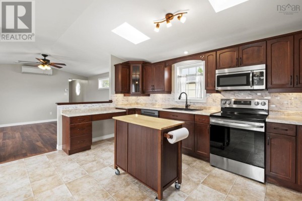Interior view of the kitchen and adjacent living area with hardwood floors and a ceiling fan. - 49 Merriweather Crescent, Garlands Crossing