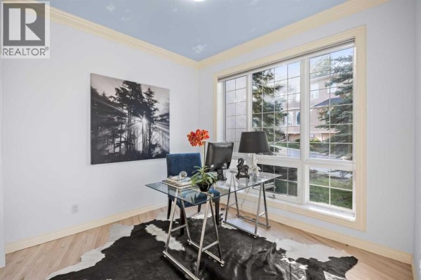 Hallway with a decorative ceiling, built-in shelving, and artwork on the walls. - 49 Patina Terrace Sw, Calgary