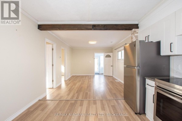 View from the kitchen into the living area, showing appliances and doorways. - 49 Randolph Street, Welland