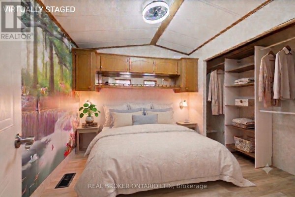 Front exterior of a taupe mobile home with a covered porch and pink door. - 490 Spruce Street, Centre Wellington