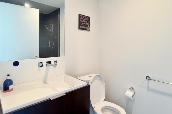 Bathroom with a white vanity, vessel sink, chrome faucet, and a toilet. - 4901 - 101 Charles Street E, Toronto