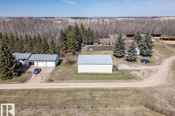 Close-up aerial view of the residential buildings, garage, detached metal shed, and landscaping. - 49059 Rge Road 265, Rural Leduc County