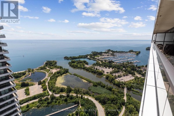Aerial view of a marina, parkland with ponds, and islands beside a wide blue lake. - 4908 - 30 Shore Breeze Drive, Toronto