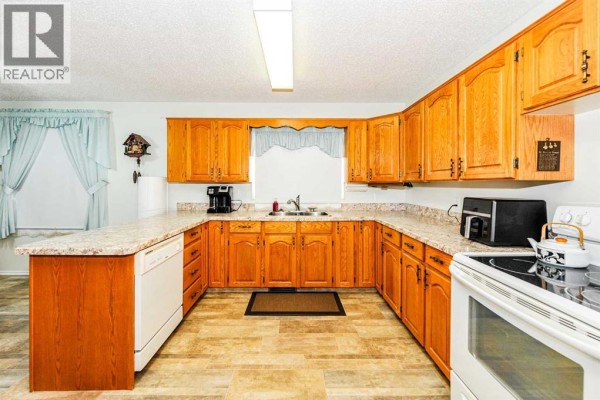 Spacious kitchen with light wood cabinets, granite countertops, and white appliances. - 4912 56 Avenue, Ryley