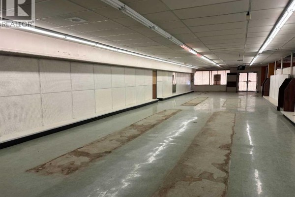 Interior view showing empty space with display panels and concrete floor. - 4919 50 Street, Rocky Mountain House