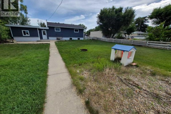 Kitchen with green cabinets, wood countertops, a white dishwasher, and a black sink. - 4931 54 Avenue, Taber