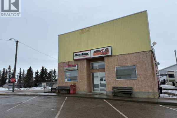 Front view of a commercial building with Racetrac signs and two benches outside. - 4934 50 Avenue, Kitscoty