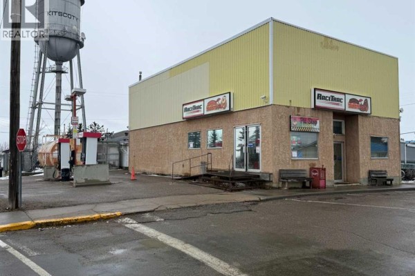 Commercial building with gas pumps and a water tower in the background. - 4934 50 Avenue, Kitscoty