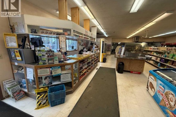 Interior view of a convenience store with a counter, shelves, and a freezer chest. - 4934 50 Avenue, Kitscoty