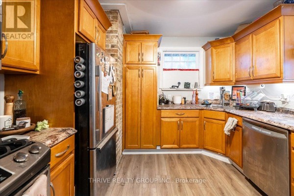 Kitchen with wood cabinets, granite counters, brick backsplash, and stainless steel appliances - 494 Highbury Avenue N London East