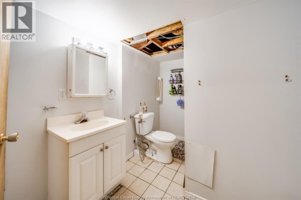 A bedroom with sloped ceilings, a black metal bed frame, and white walls. - 494 Rankin, Windsor