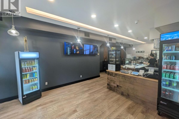 Interior view of restaurant counter, refrigerator displays, and a television screen on the wall. - 495 Bloor Street W, Toronto