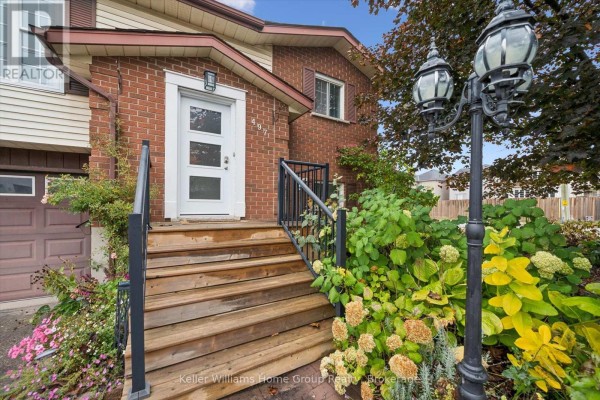 Close-up of the front entrance stairs, walkway, and landscaping with a lamppost. - 497 Forfar Street E, Centre Wellington