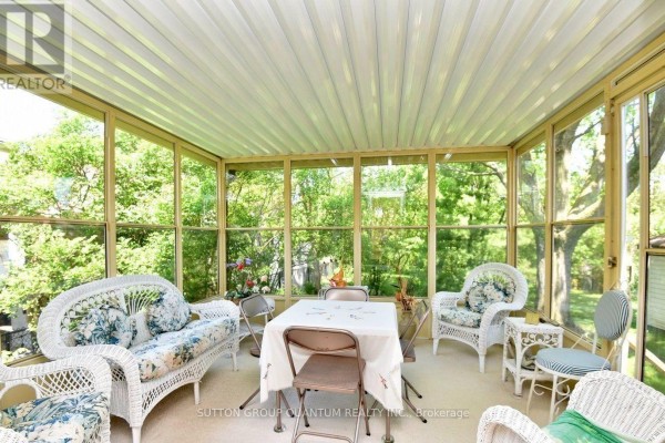 Sunroom with wicker furniture and floral cushions - 499 Valley Drive N Oakville